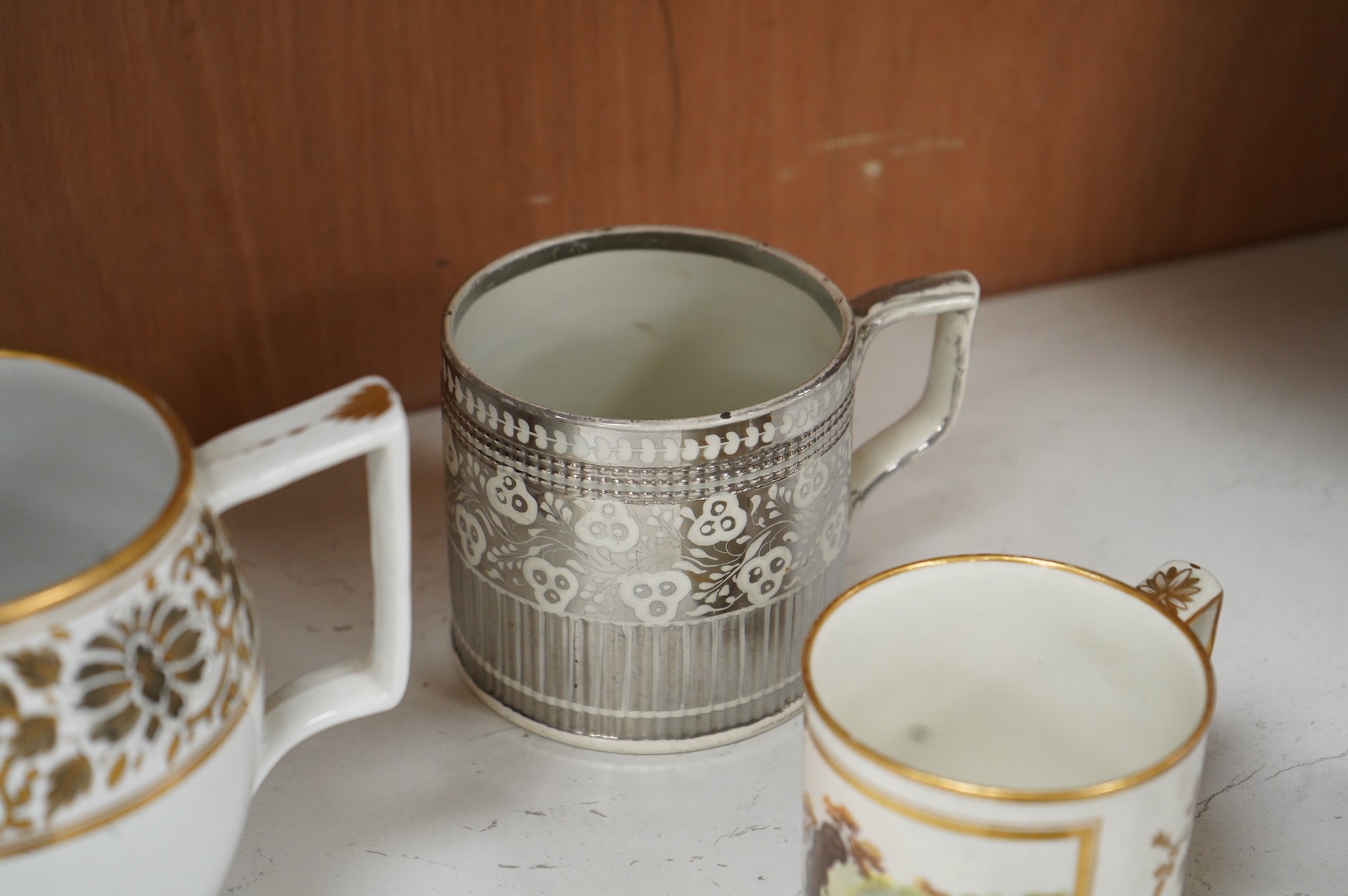 A pair of early 19th century English porcelain large mugs with gilt bands and five other early 19th century porcelain or pearlware mugs, one inscribed SG, Forget Me Not, largest each 14cm high
